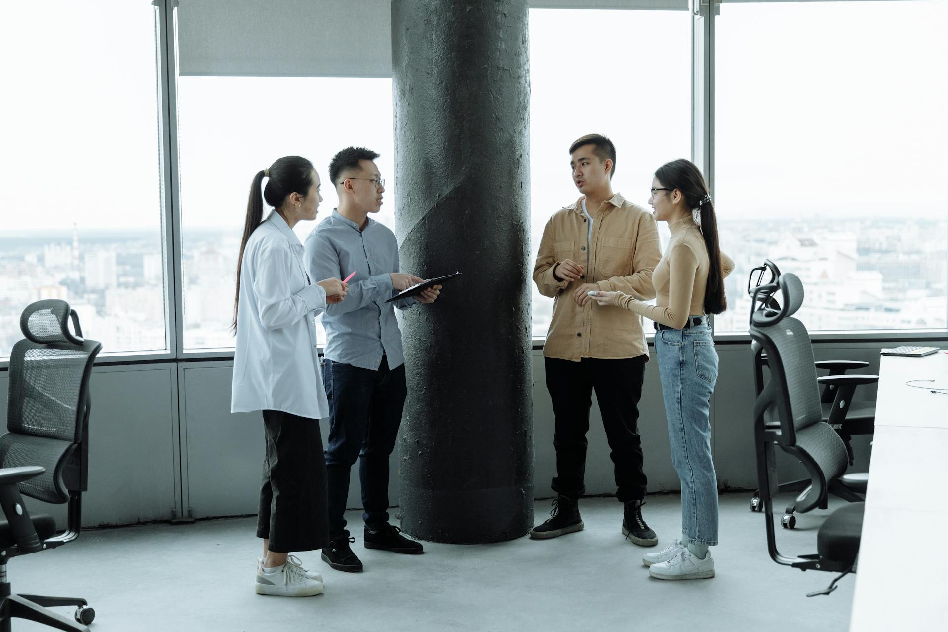 Equipe reunida em pé discutindo ideias em ambiente corporativo durante treinamento colaborativo e dinâmico