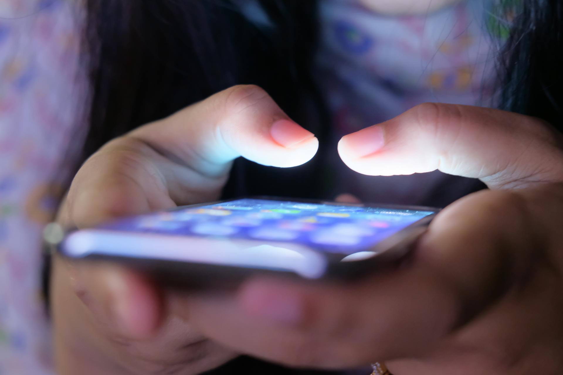 Mãos interagindo com celular, foco em estratégias para engajamento em redes sociais