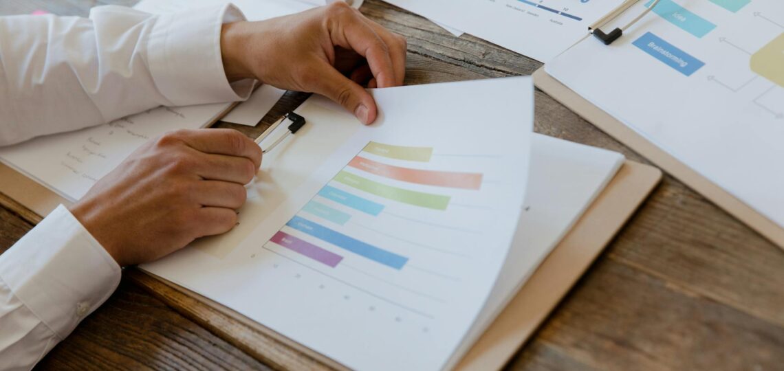 Profissional analisando gráficos coloridos em relatório de recursos humanos com IA