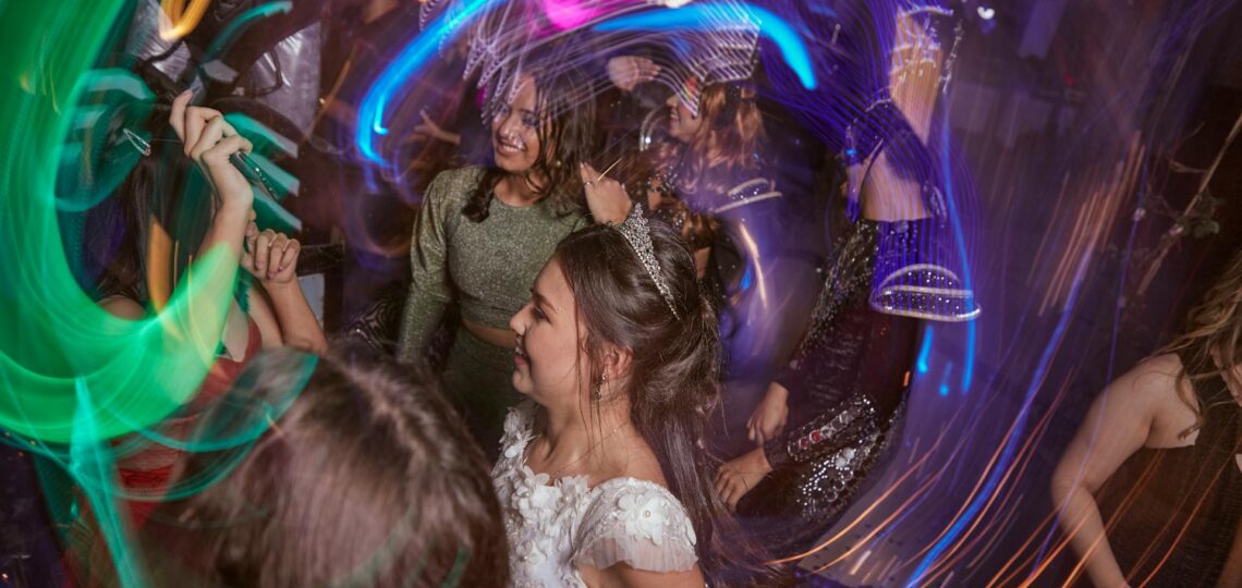 jovens dançando com luzes coloridas em movimento em festa de debutante