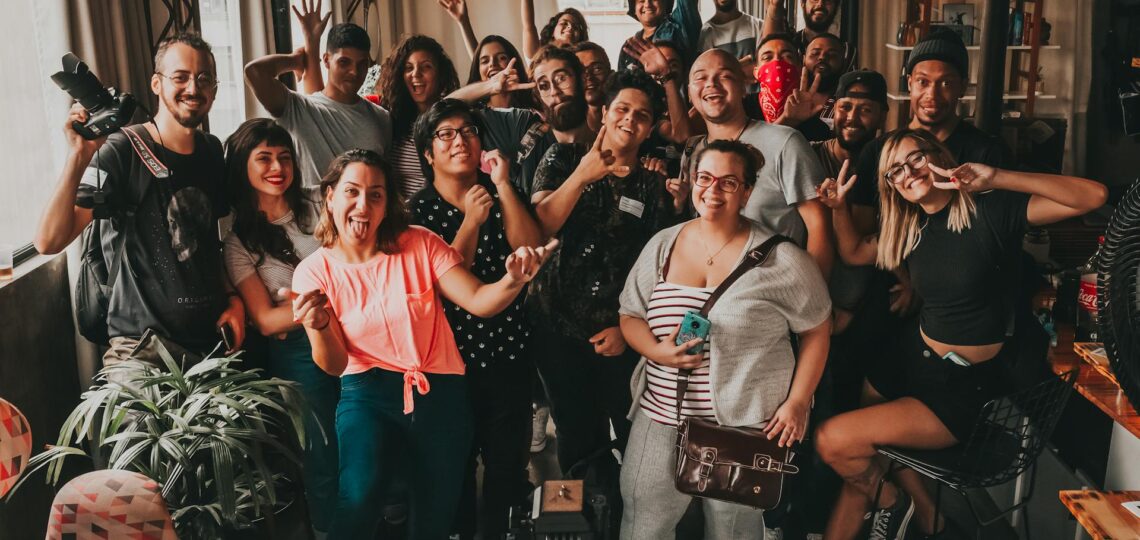 Grupo animado de pessoas celebrando em uma festa criativa e descontraída em ambiente interno