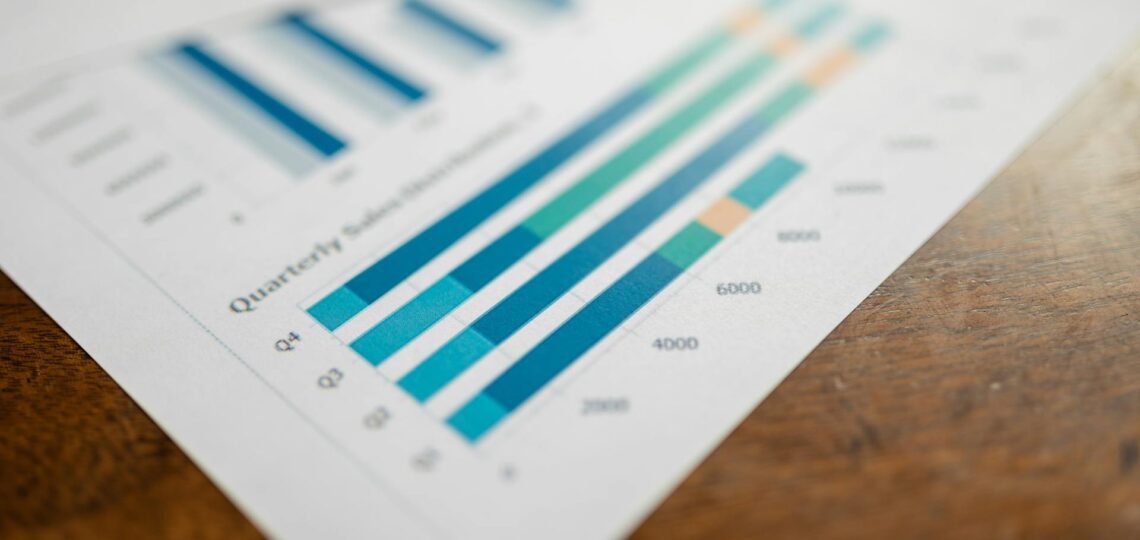 Gráfico de desempenho com dados de produtividade trimestral em relatório impresso sobre mesa de madeira.