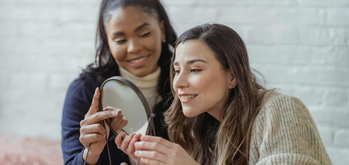 Cliente satisfeita observando o resultado da maquiagem em salão de beleza moderno com atendimento personalizado