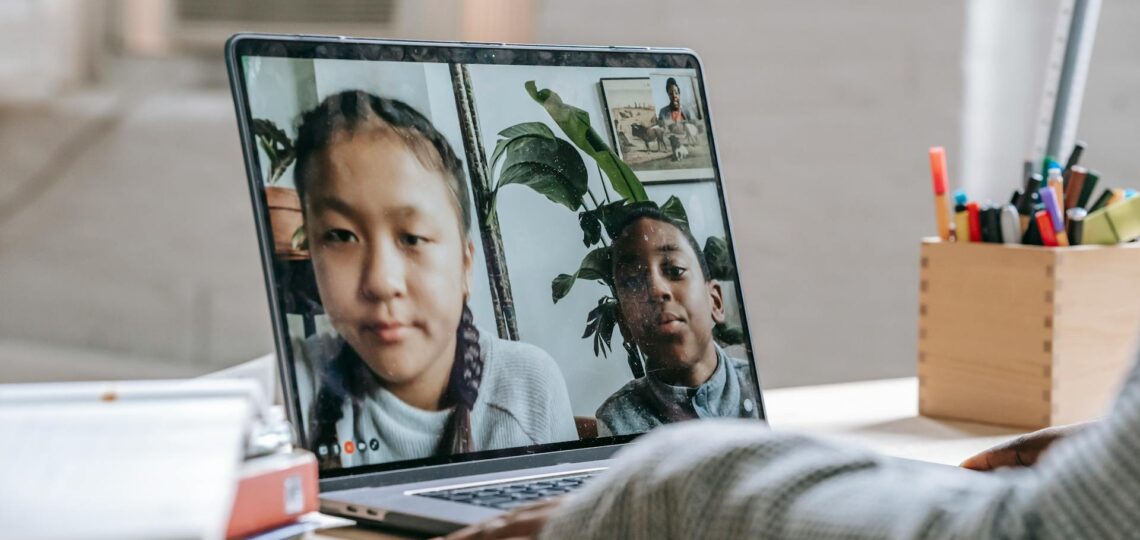 Crianças em aula online interativa com uso de tecnologia educacional.