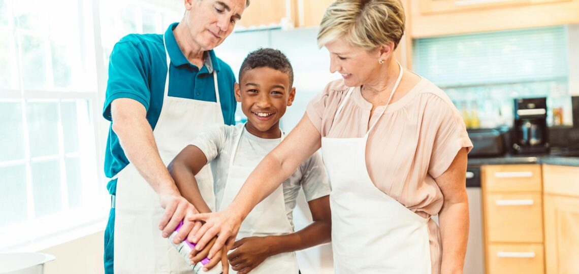 Família cozinhando junta com alegria e criatividade usando tecnologia na cozinha