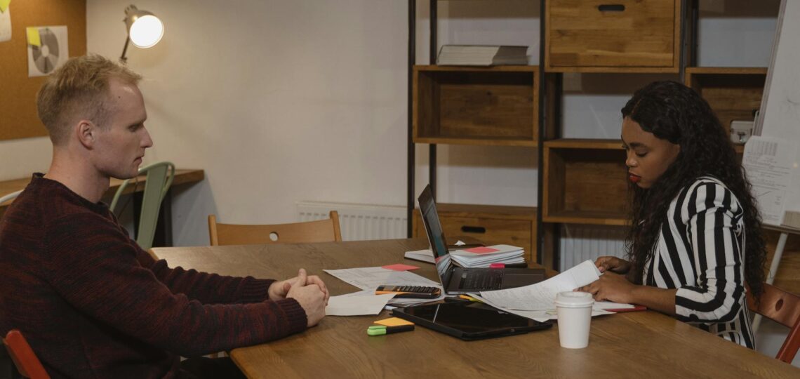 Entrevista de emprego em andamento com uso de tecnologia e análise de currículos