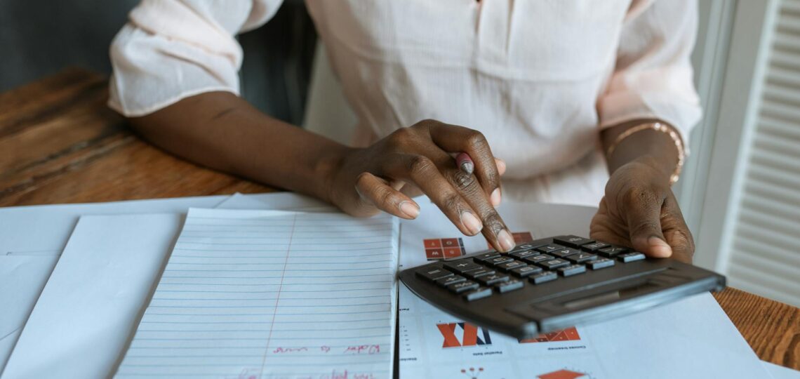 pessoa fazedno calculos com calculadora e anotações