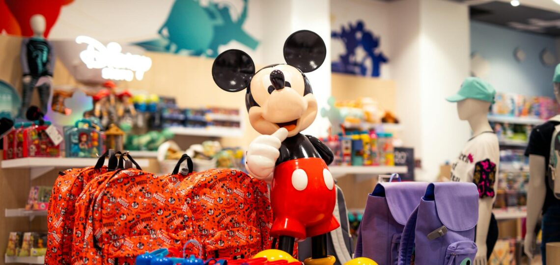 loja de artigos infantis com um bonecos e mochilas em primeiro plano