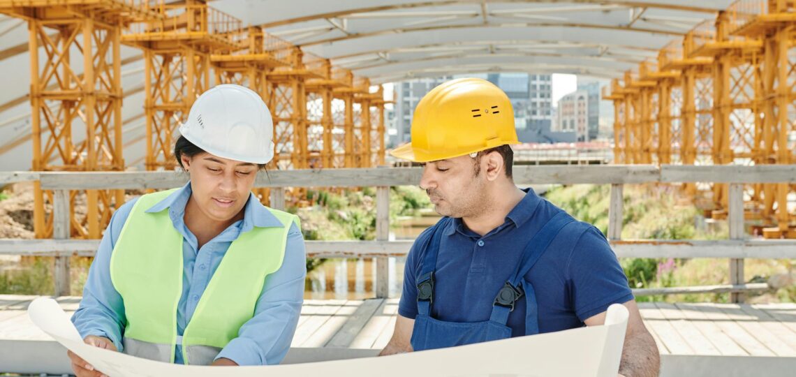 dois engenheiros com projeto em mãos