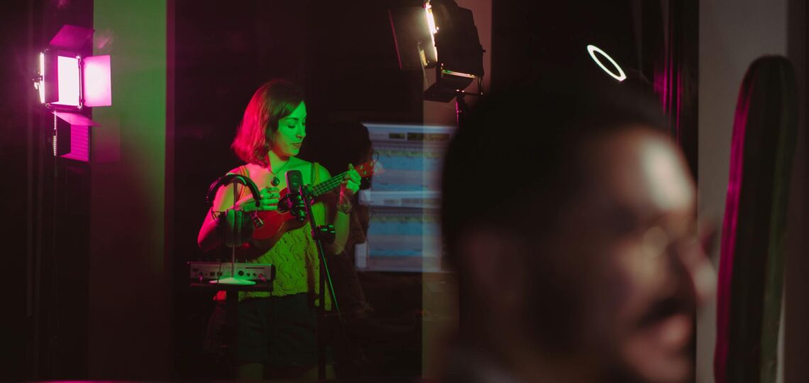 estúdio de gravação com uma musicista tocando cavaquinho