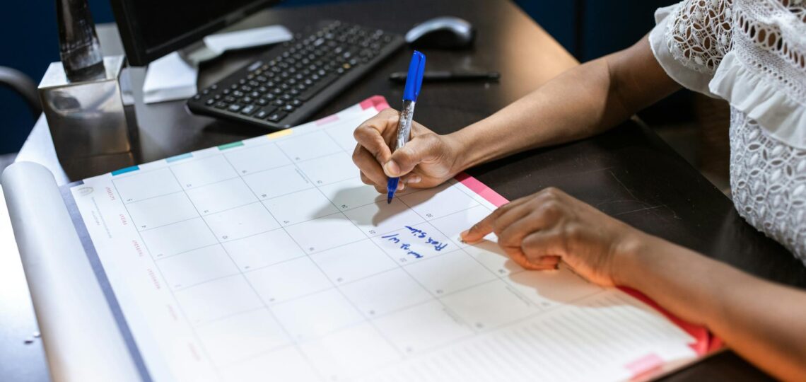 mulher fazendo anotações em uma agenda sobre a mesa