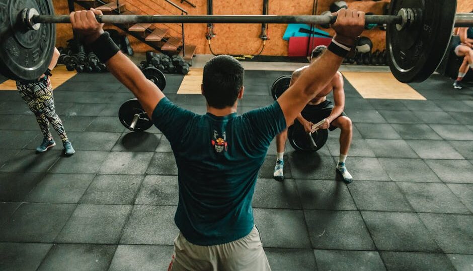 A group of men engaged in a vigorous weightlifting session at a gym.
