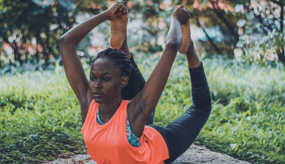 A woman practicing a yoga pose outdoors, emphasizing flexibility and fitness.