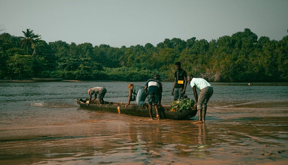 Fishermen in Cabinda, Angola, ready their canoe for a day on the river. Scenic landscape.