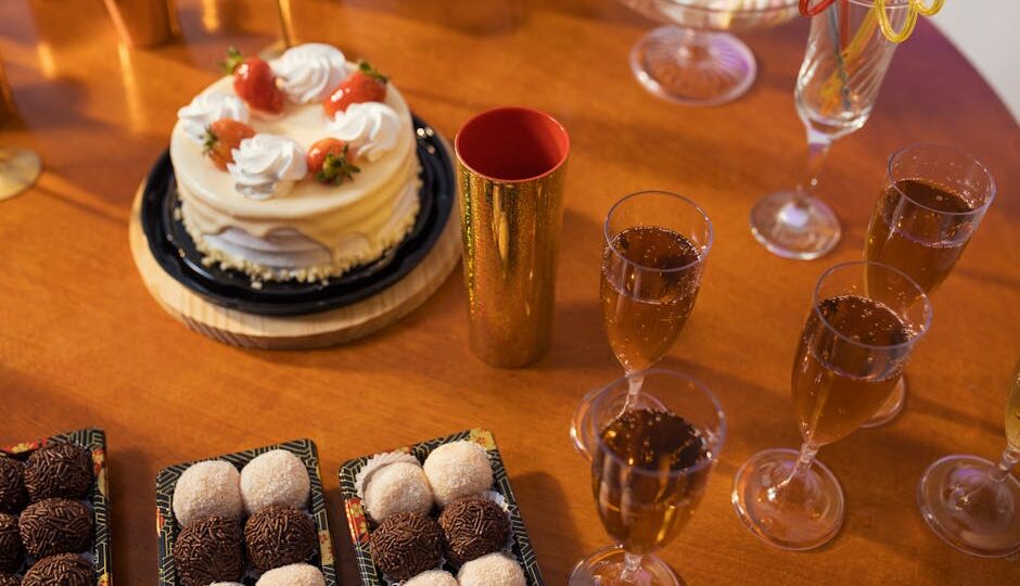 Celebrate with a delicious spread of cake, brigadeiros, and sparkling drinks on a festive table.