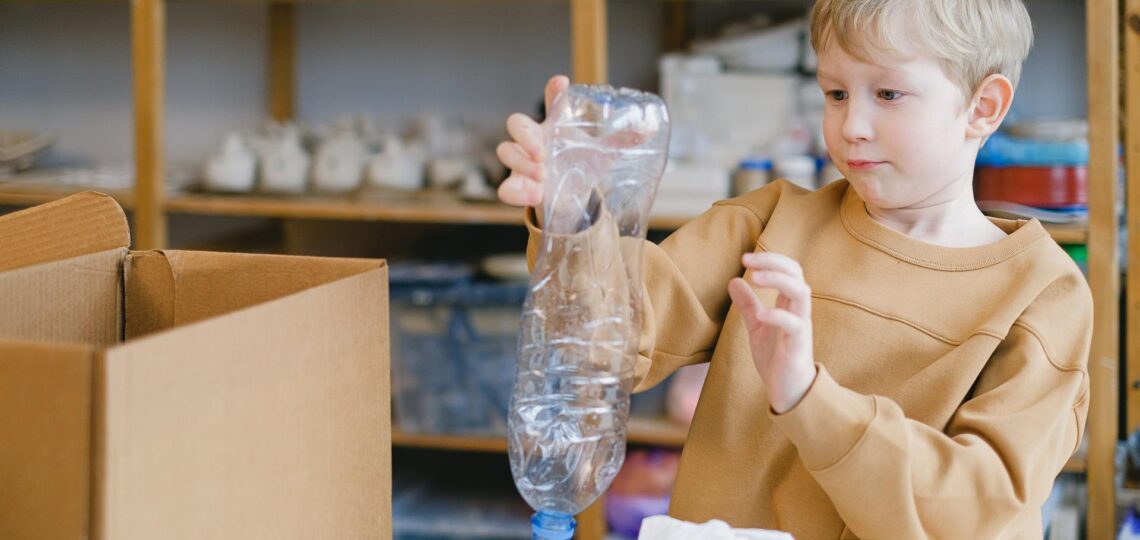 menino separando garradas de plástico para destinação correta de descarte