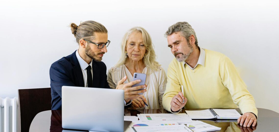 casal conversando com homem olhando tela de laptop