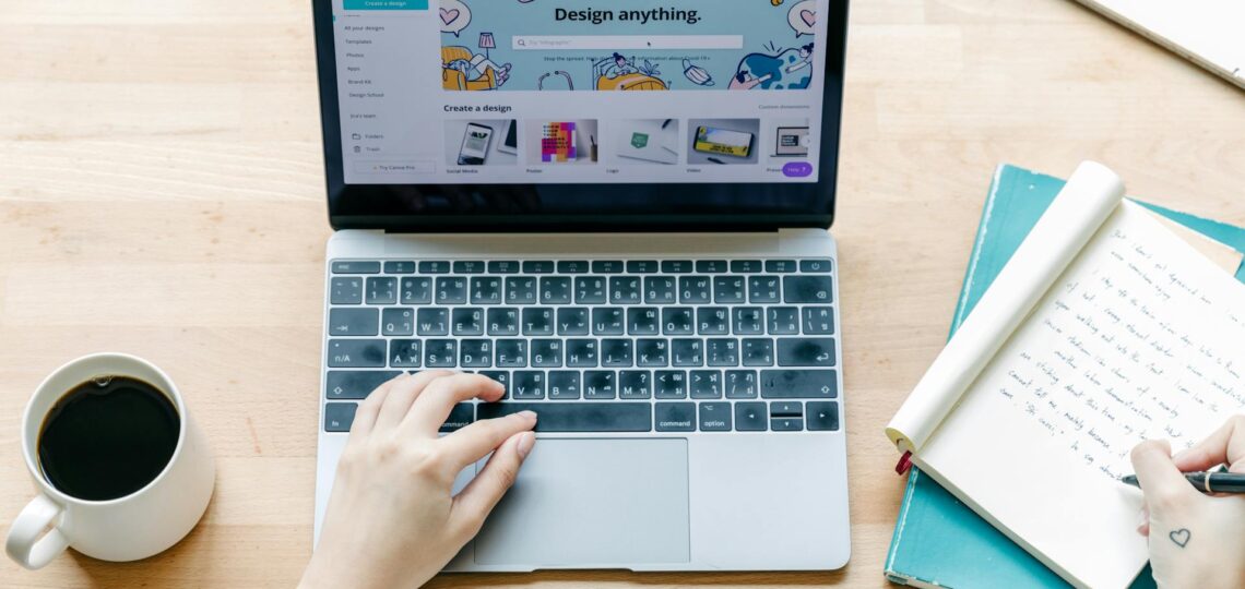 laptop sobre a mesa de sartup com ponto de vista do profissional e sua mão teclando