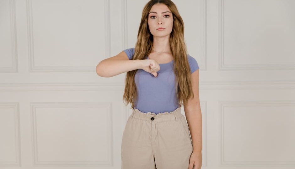 Young woman gesturing in sign language indoors, expressing communication visually.