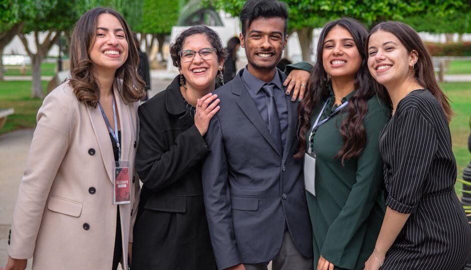 A group of diverse colleagues smiling together, showcasing teamwork and friendship outdoors.