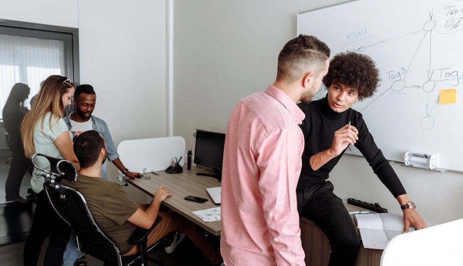 Diverse team engaged in productive office discussion, sharing ideas on a project.