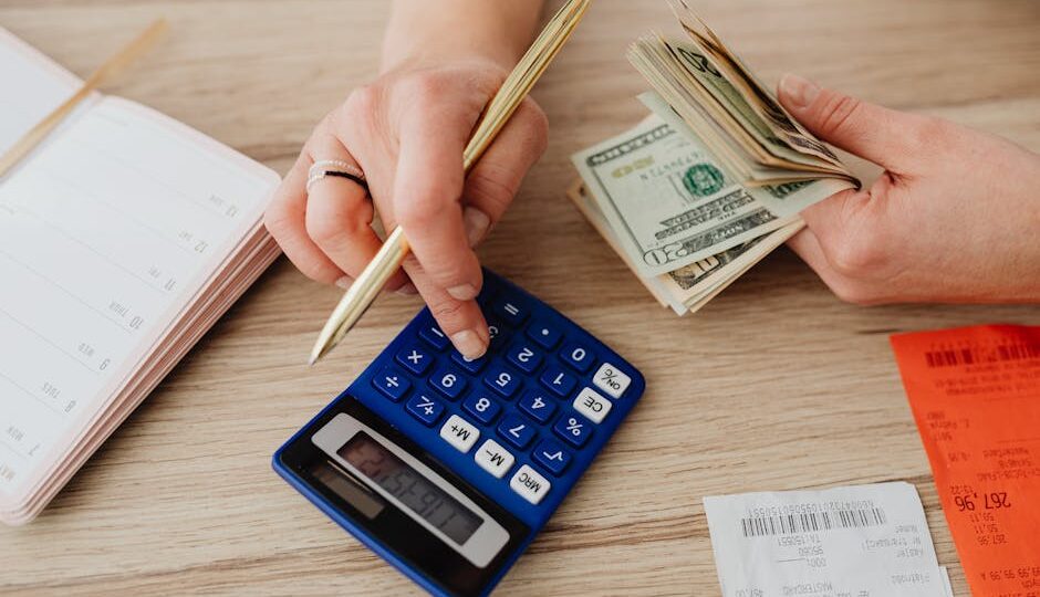 Hands handling cash and calculator for budget planning. Modern financial scene.