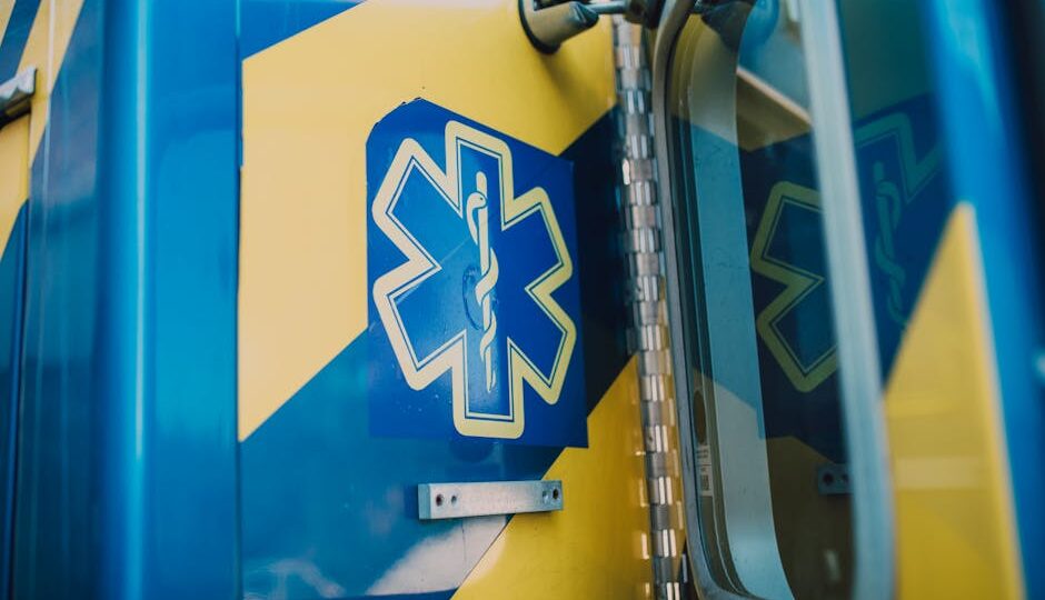 Vibrant blue and yellow medic symbol on an ambulance door, representing emergency medical services.