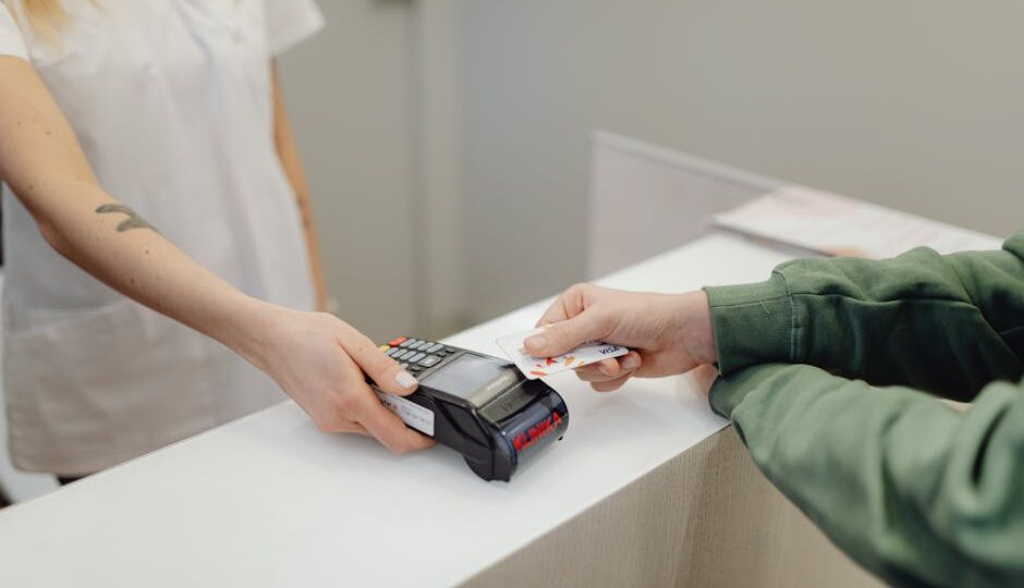 Person using a bank card for contactless payment at a modern checkout counter.