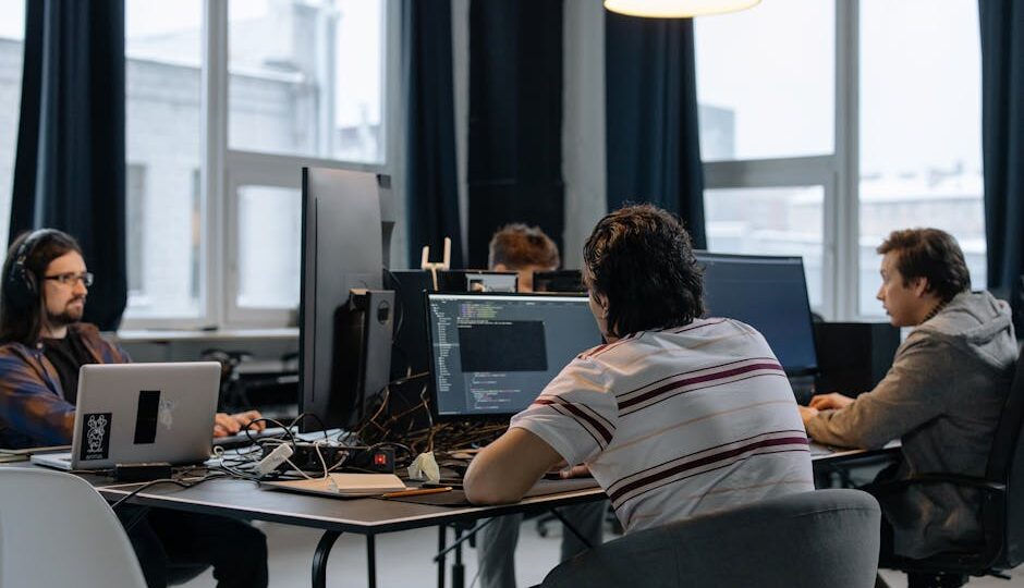 Team of developers working together on computers in a modern tech office.
