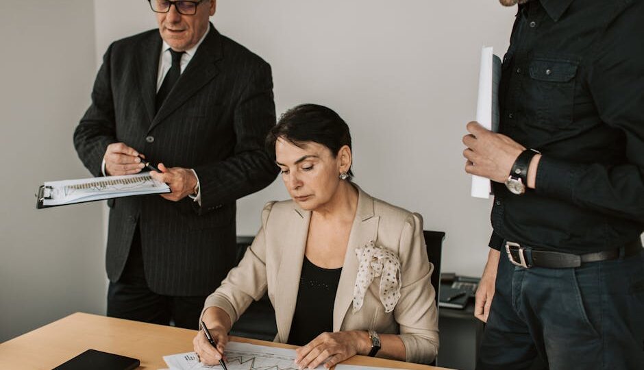 Business professionals collaborating on financial documents in an office setting.