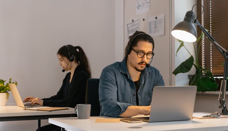 Two call center employees working diligently with headsets in the office.