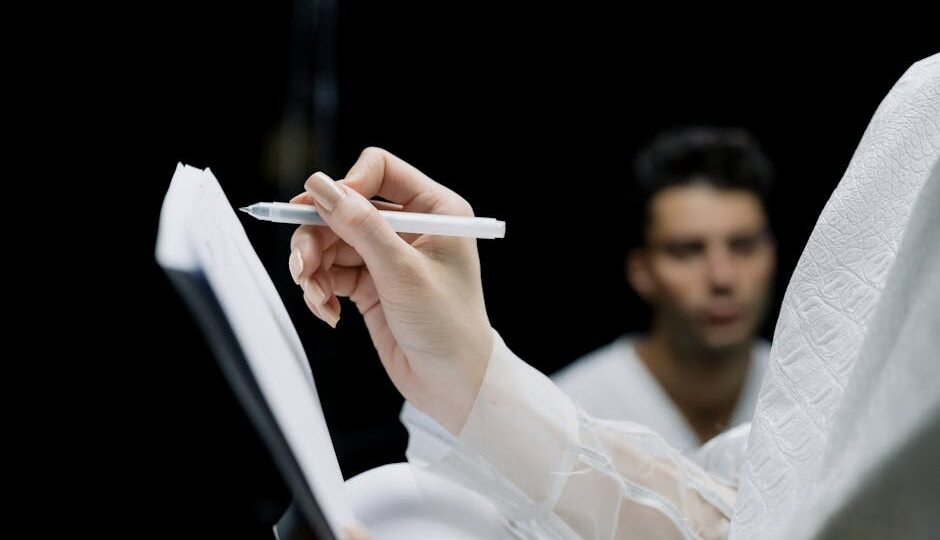 Focused shot of a hand writing notes on a notepad with a pen, background blurred.