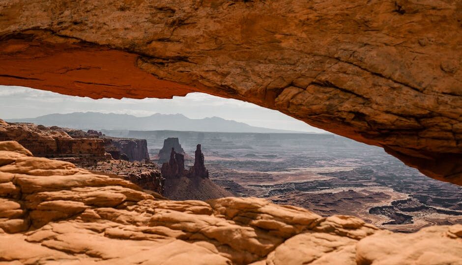 Breathtaking view through Mesa Arch in Utah's Canyonlands National Park at sunset. Marvel at the stunning rock formations.