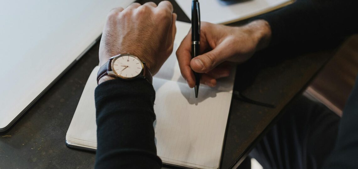 executivo analisando tarefas e pendencias na mesa no escritótio olhando que horas são no relógio