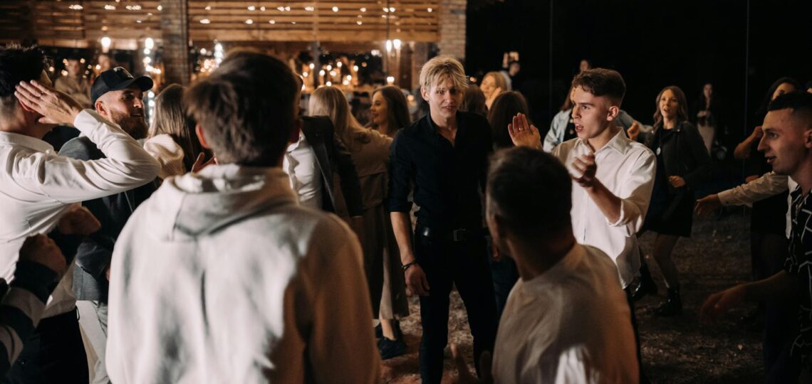 festa com pessoas dançando a noite e ao ar livre com decoração iluminada