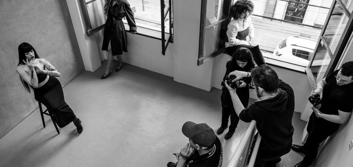 estúdio fotográfico durante sessão de fotos com modelo feminino, fotógrafo e sua equipe de profissionais