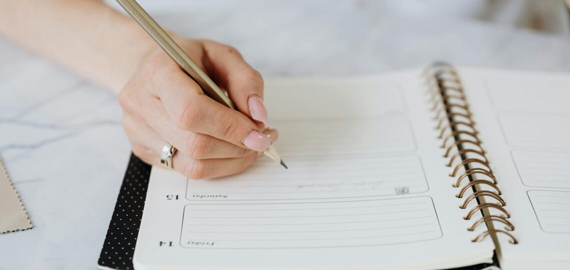 mulher anotando seus compromissos em uma agenda