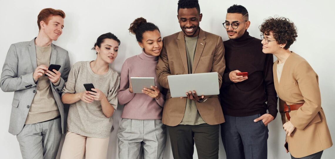 grupo de pessoas olhando a tela de um laptop de um homem que acaba de criar campanha para redes sociais