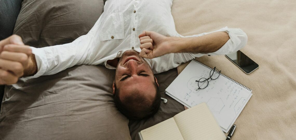 homem deitado no sofa da sala descansando cansado