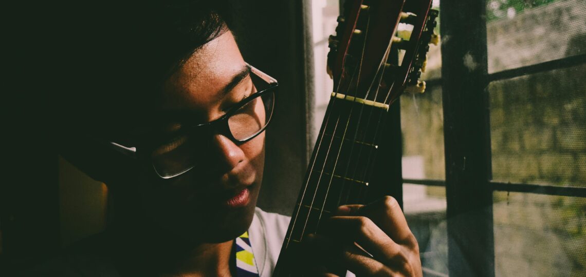 homem tocano um violão concentrado